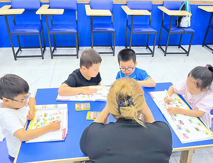Hình Ảnh Các Bé Tô Màu Và Làm Bài Tập Nhóm Cùng Giáo Viên Bản Ngữ